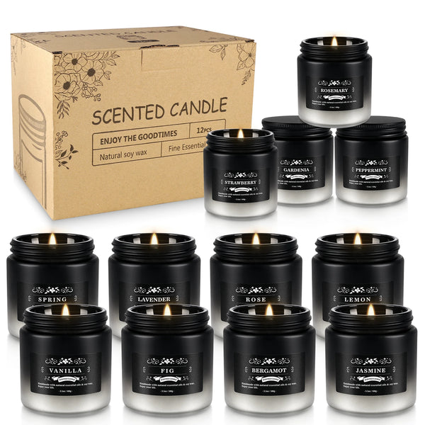 A collection of scented soy wax candles in black jars and a cardboard box, featuring scents like Rosemary, Strawberry, and Va