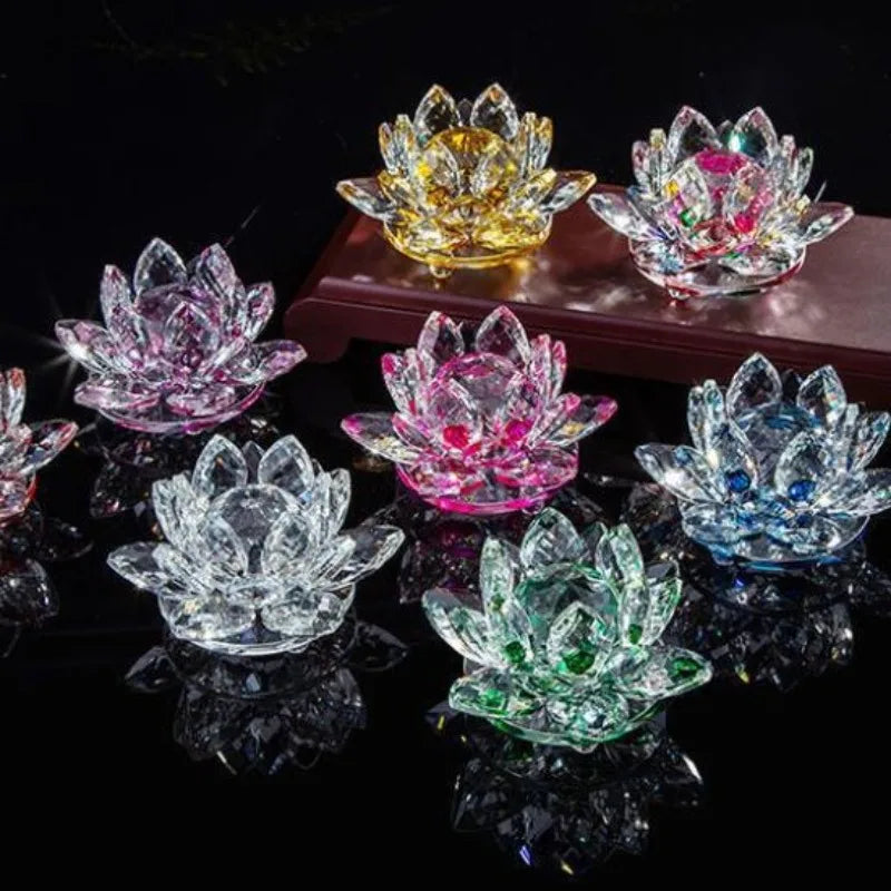 A collection of crystal lotus flower ornaments in various colors, including yellow, pink, and blue, displayed on a dark surfa