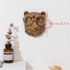 A bronze deer head storage hook wall decor mounted on a white wall next to a glass bottle.