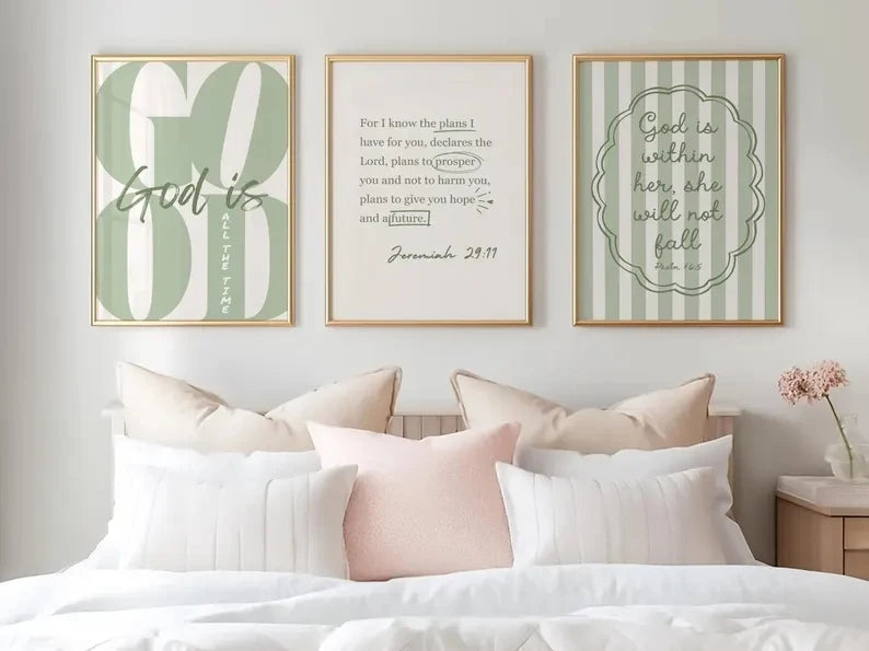 Un mur de galerie avec trois tirages de scriptures chrétiennes encadrées sur un mur blanc au-dessus d'un lit.