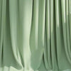 A drape of sage green stretch spandex tablecloth with a flowing skirt.