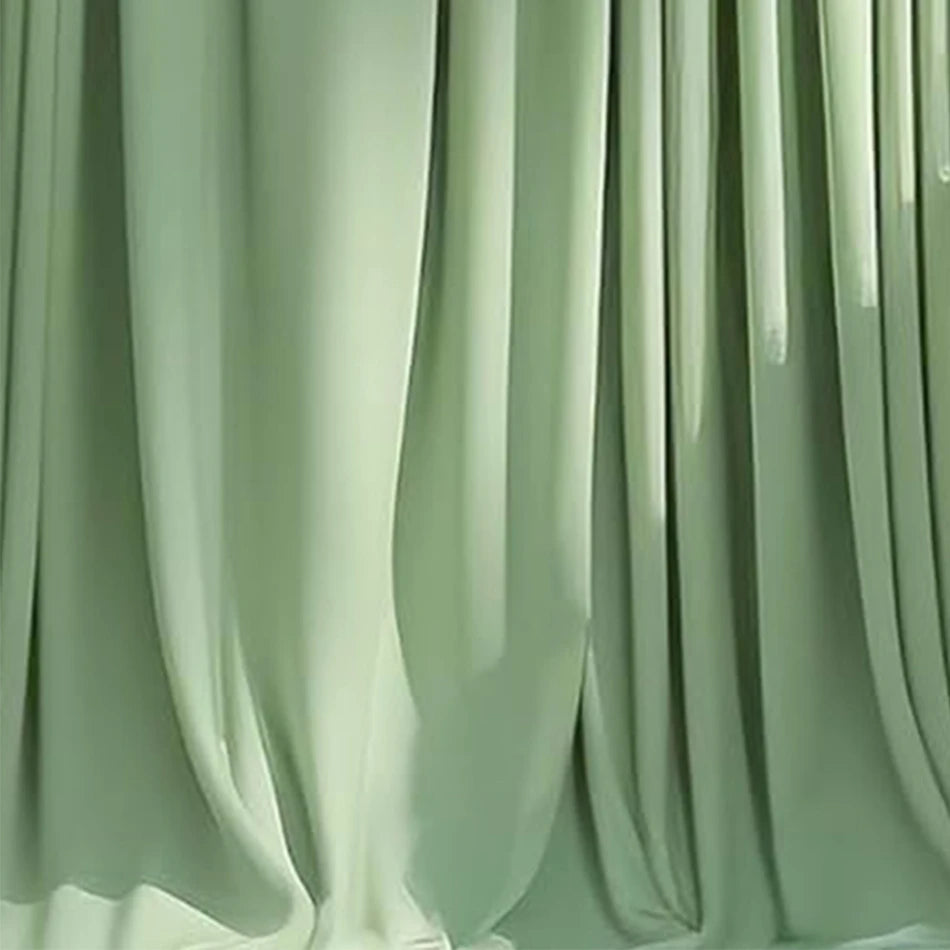A drape of sage green stretch spandex tablecloth with a flowing skirt.