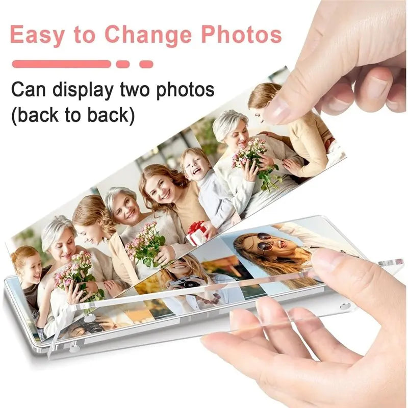 A hand is holding a clear acrylic photo frame set, demonstrating its ability to display two photos back to back.