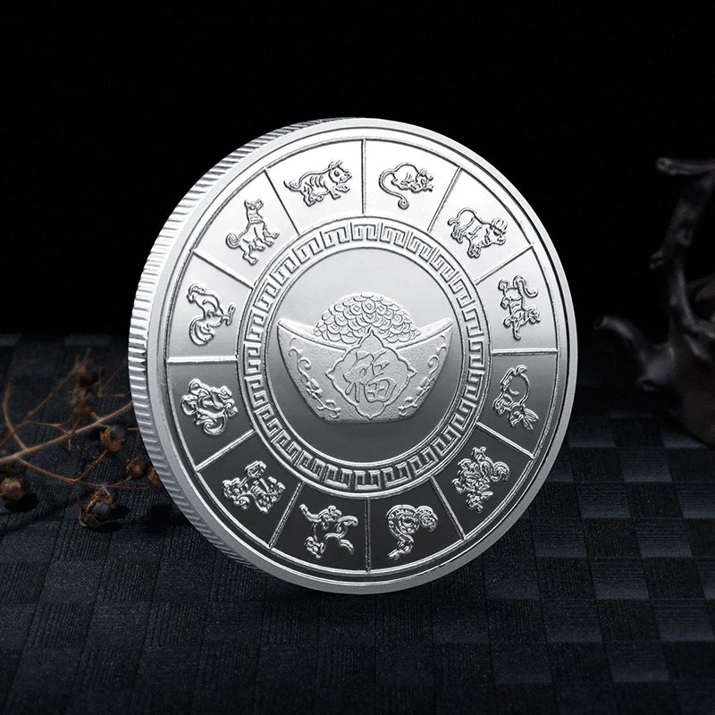 A silver collectible coin featuring various mythical creatures and a central dragon design on a dark background.