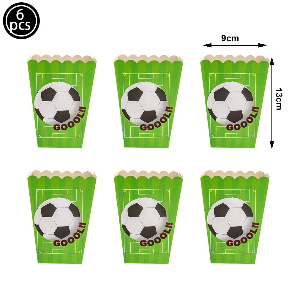 Sechs Fußball-inspirierte Cupcake-Topper in grünen Papietbechern mit Fußballdesign.