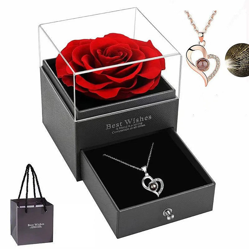 Rote Rosenkette in einer schwarzen Geschenkbox mit herzförmigem Anhänger und einem separaten Herzcharm.