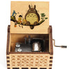 A hand-cranked wooden music box featuring a Totoro design, with an illustration of two children and a large cat on the lid.