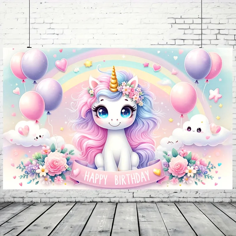 A pastel pink unicorn backdrop featuring balloons, a rainbow, clouds, and floral decorations for a birthday party.