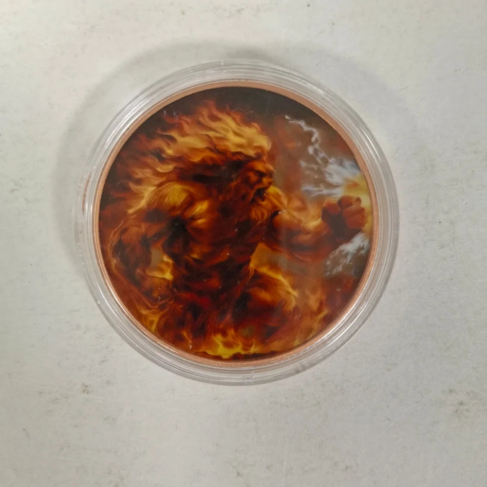 A challenge coin featuring a fierce, fiery depiction of a mythical creature or figure.