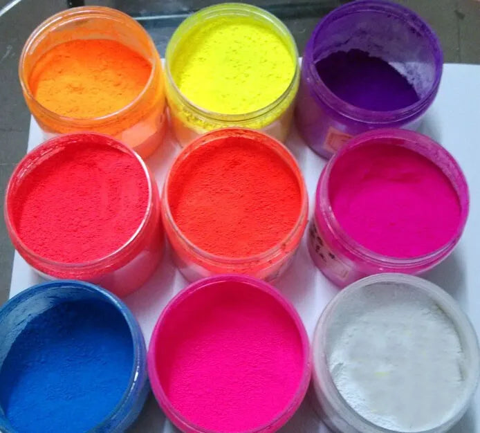 A collection of 13 vivid neon fluorescent pigment powders in various bright colors including orange, yellow, pink, purple, an