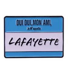 Blue and pink enamel pin with text saying Oui oui mon ami Je m'appelle Lafayette