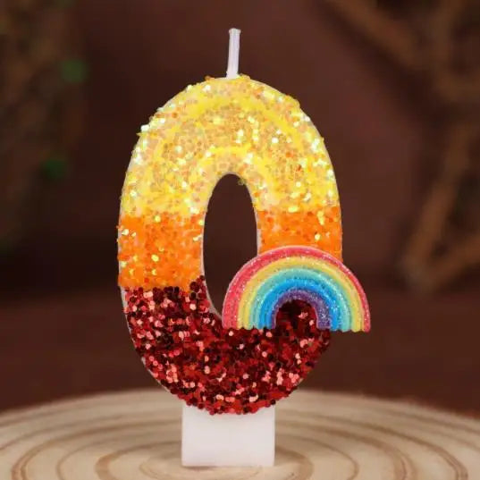 Rainbow sequined number candles shaped like the number 0, featuring yellow, orange, and a rainbow colored base.