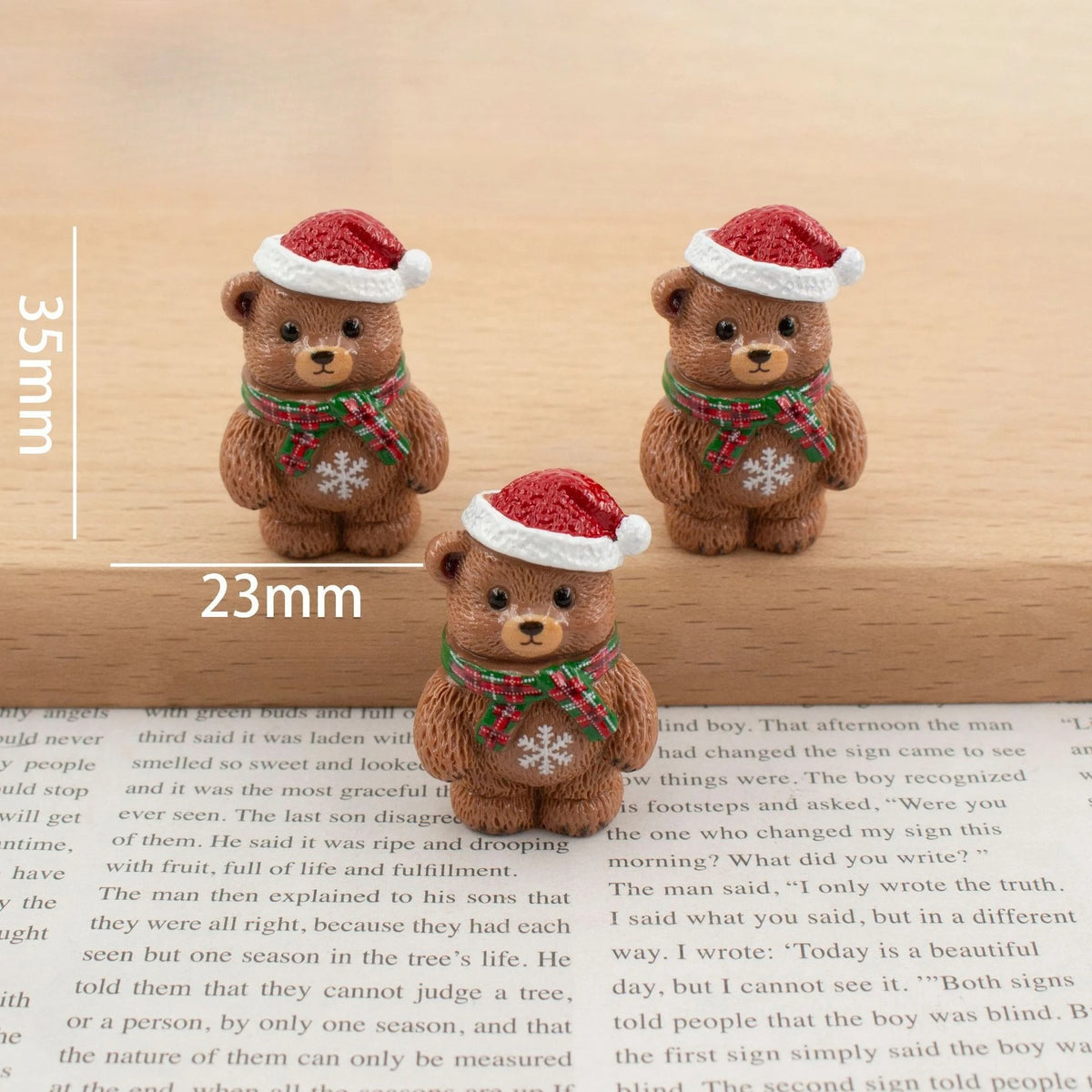 A set of festive Christmas resin decor featuring two small brown teddy bears with red hats and green plaid scarves.
