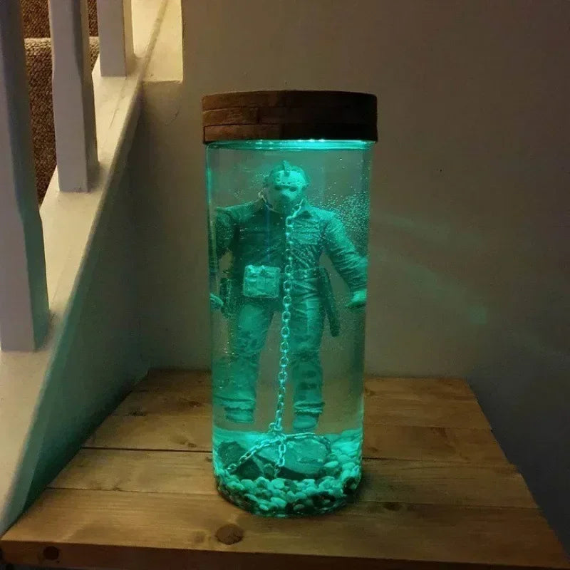 A collectible lamp featuring a Jason Voorhees figure submerged in glowing teal liquid inside a glass jar.