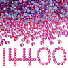 A pile of mixed size crystal and glass rhinestones in shades of pink, purple, and red.