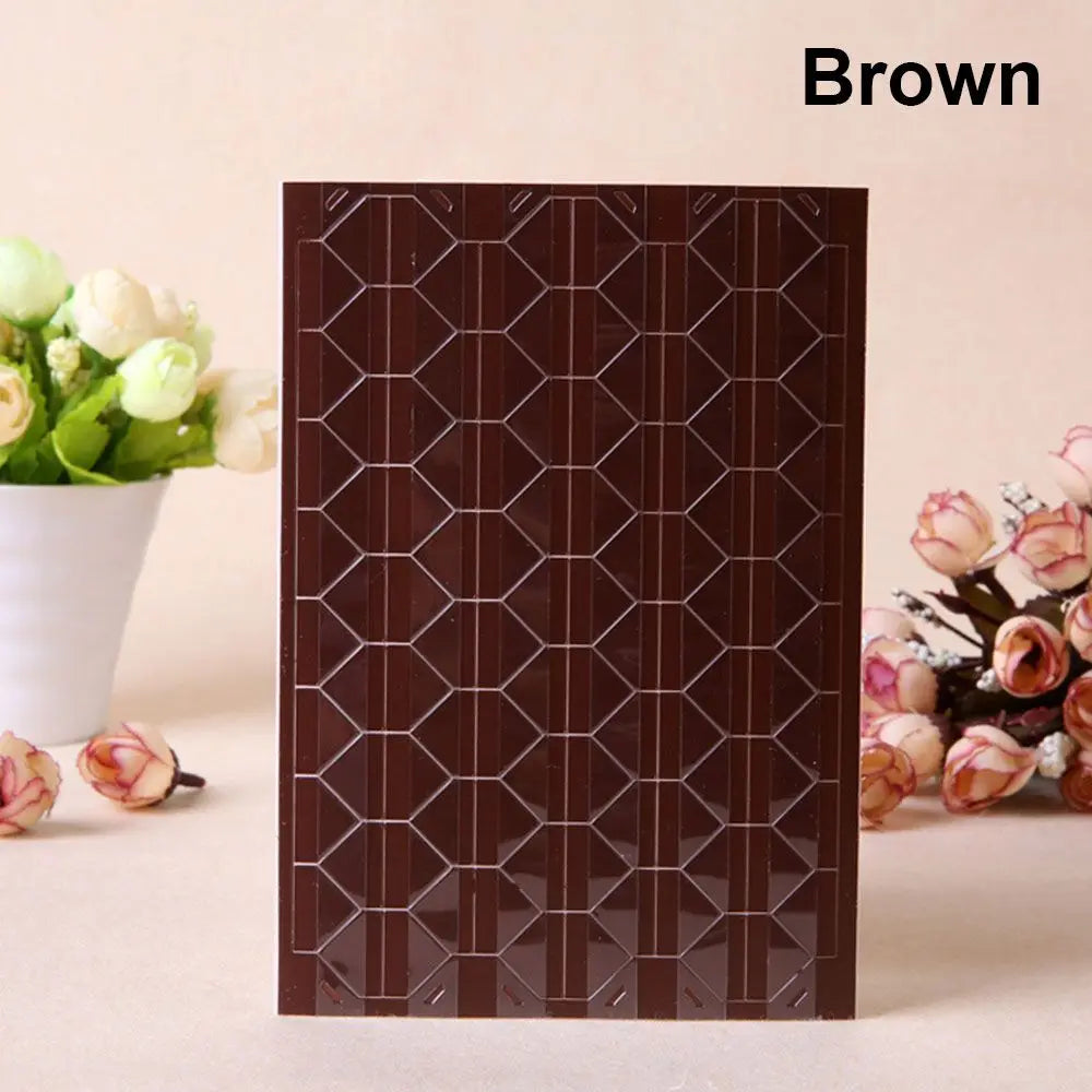 A brown PVC photo corner protector with a geometric pattern is displayed next to white flowers.