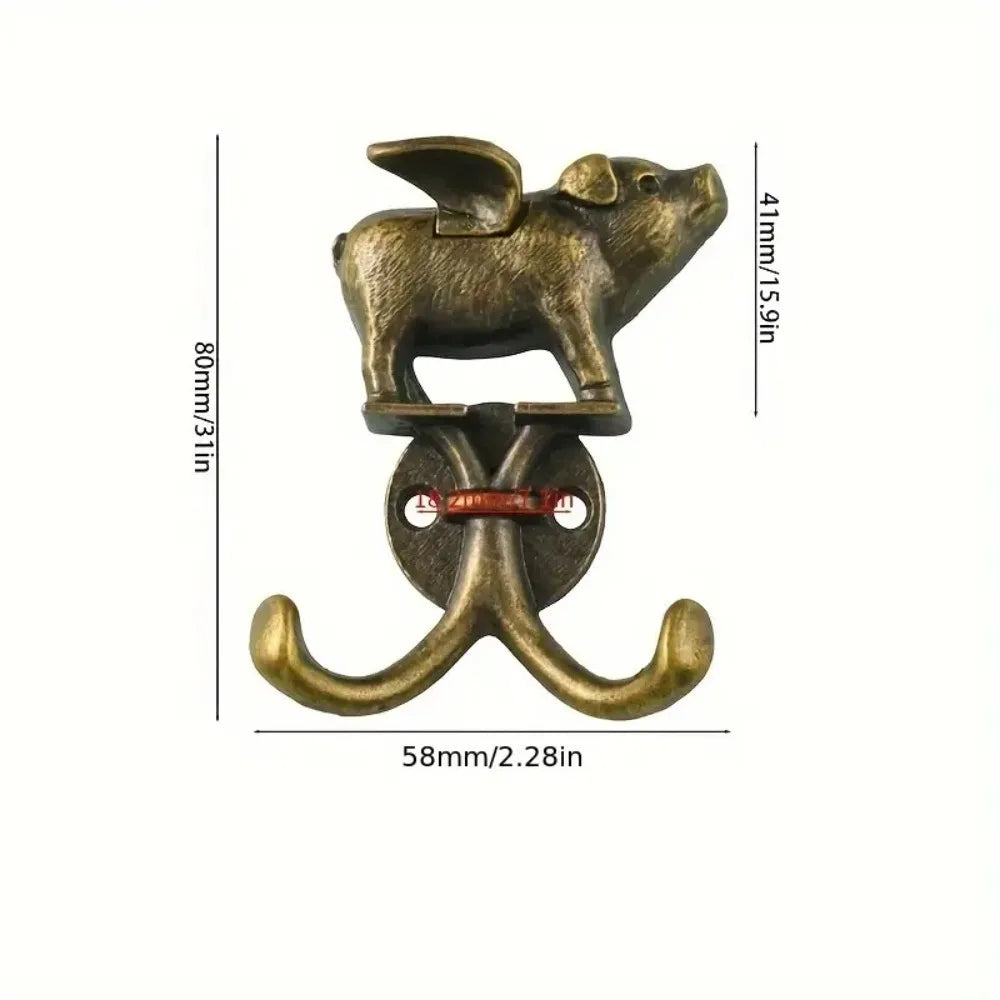 A decorative metal wall hook shaped like a pig, used for hanging items.