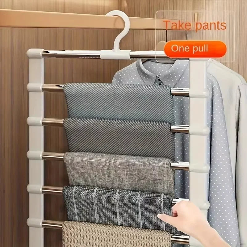 A white multi-layer pants hanger with stainless steel rods is shown holding folded gray and blue pants.