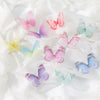 A collection of 3D embroidered butterfly patches in various shades of pink, purple, and blue on white fabric.