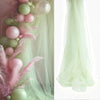 Pink and green sheer tulle draping fabric used for a wedding arch backdrop