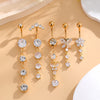 A set of five gold tone butterfly and flower belly rings displayed on a light beige background.