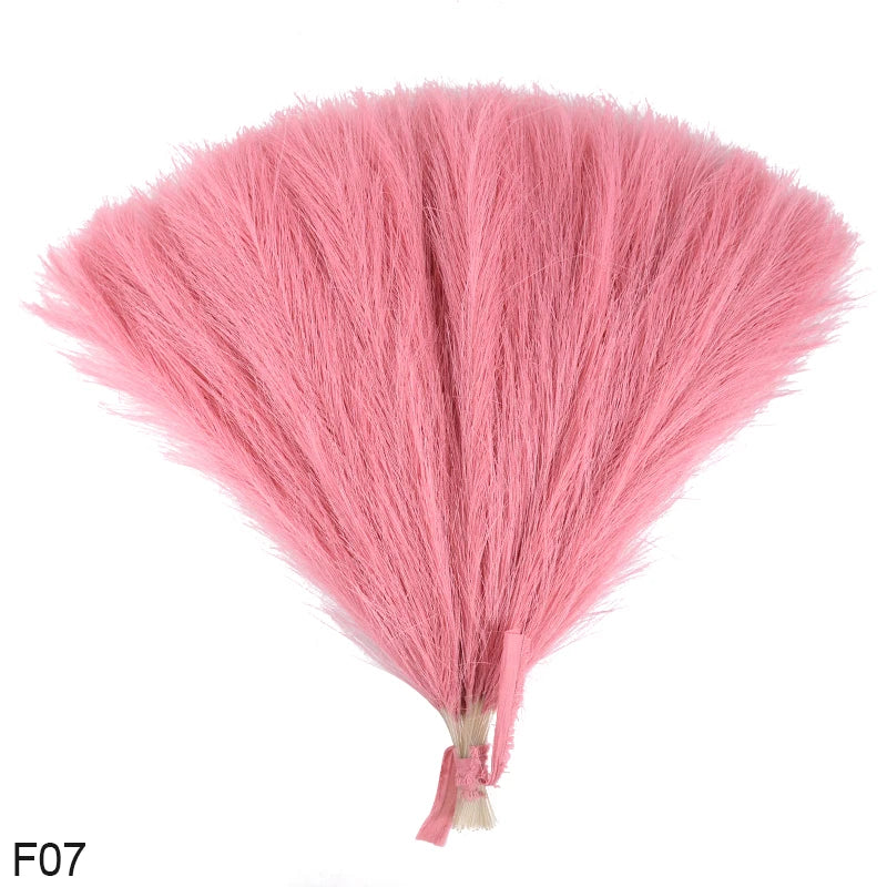 A fluffy pink artificial reed bouquet made of faux pampas grass.