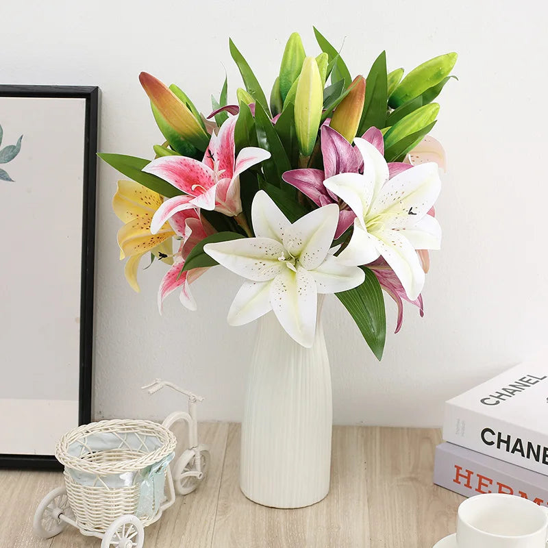 A bouquet of realistic silk lily flowers in shades of pink, white, and green arranged in a vase.