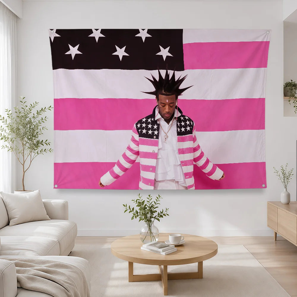 A person wearing a striped jacket stands in front of a large American flag banner featuring pink and white stripes and stars.