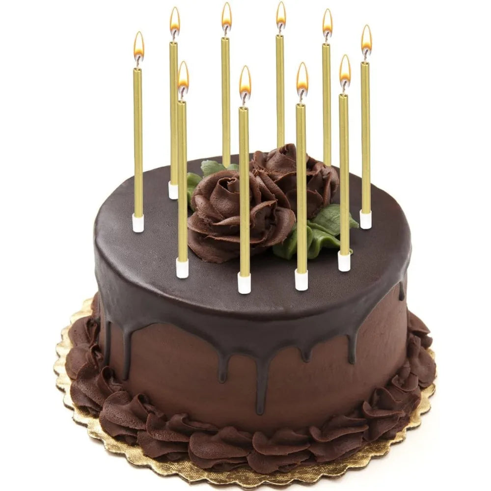 A dark chocolate birthday cake decorated with edible flowers and lit candles.