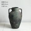 A dark gray ceramic vase with handles and an embossed world map design.