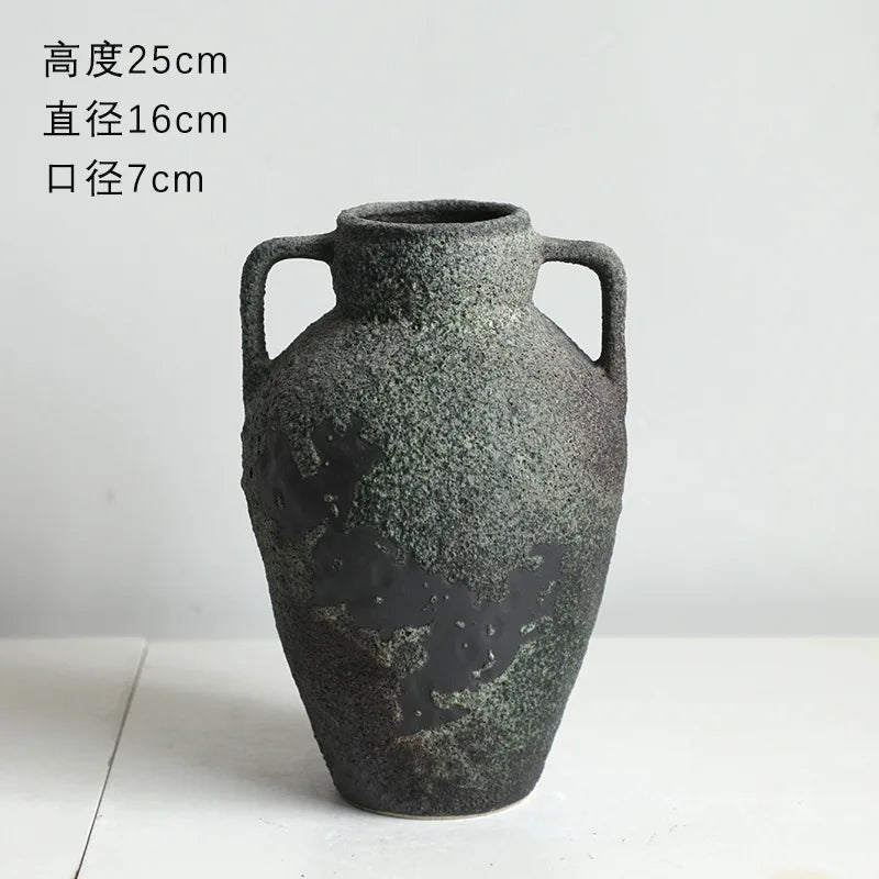 A dark gray ceramic vase with handles and an embossed world map design.