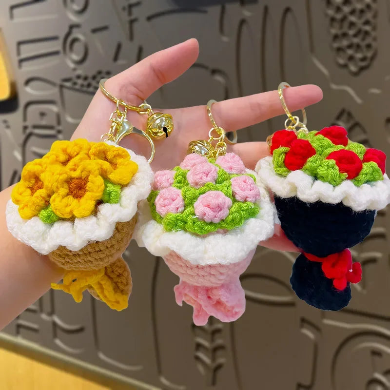 Handmade crochet flower bouquet keychain featuring yellow, pink, and red flowers on white and dark fabric.