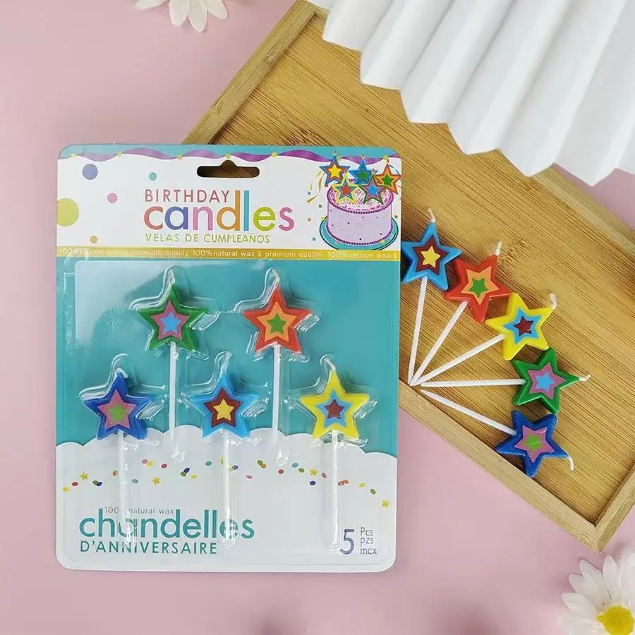 A pack of five colorful star-shaped birthday candles in a clear plastic container with a decorative cake design.