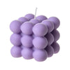 A cluster of small, round soy wax candles in light purple and white colors.