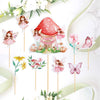 A set of fairy cupcake toppers featuring pink and white floral designs, butterflies, and a red mushroom house.
