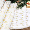 White plush faux fur Christmas tree skirt decorated with gold snowflake patterns and evergreen branches