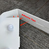 A white marquee number sign with a spherical light, showing adhesive tape for mounting on a gray fabric background.