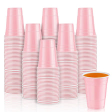 A stack of pink mini plastic shot cups for parties and events