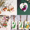 Set natürliche Sojawachs-Kerzen mit floralen und botanischen Designs auf weißem Stoff.