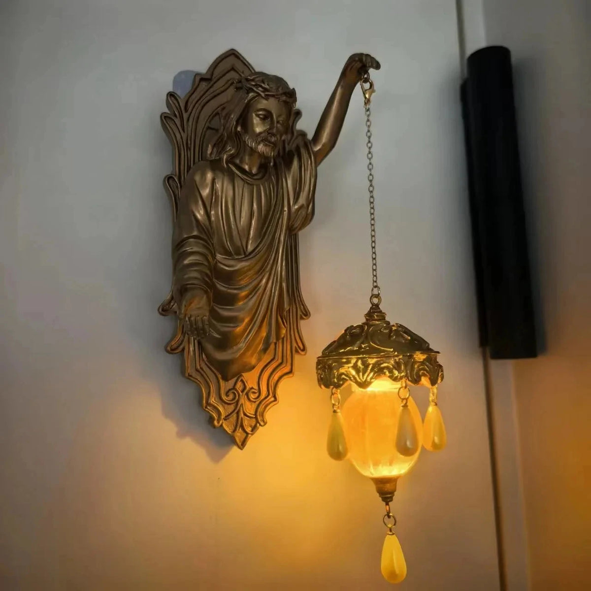 A bronze resin sculpture of a mermaid with flowing hair and a long neck, mounted on a wall.