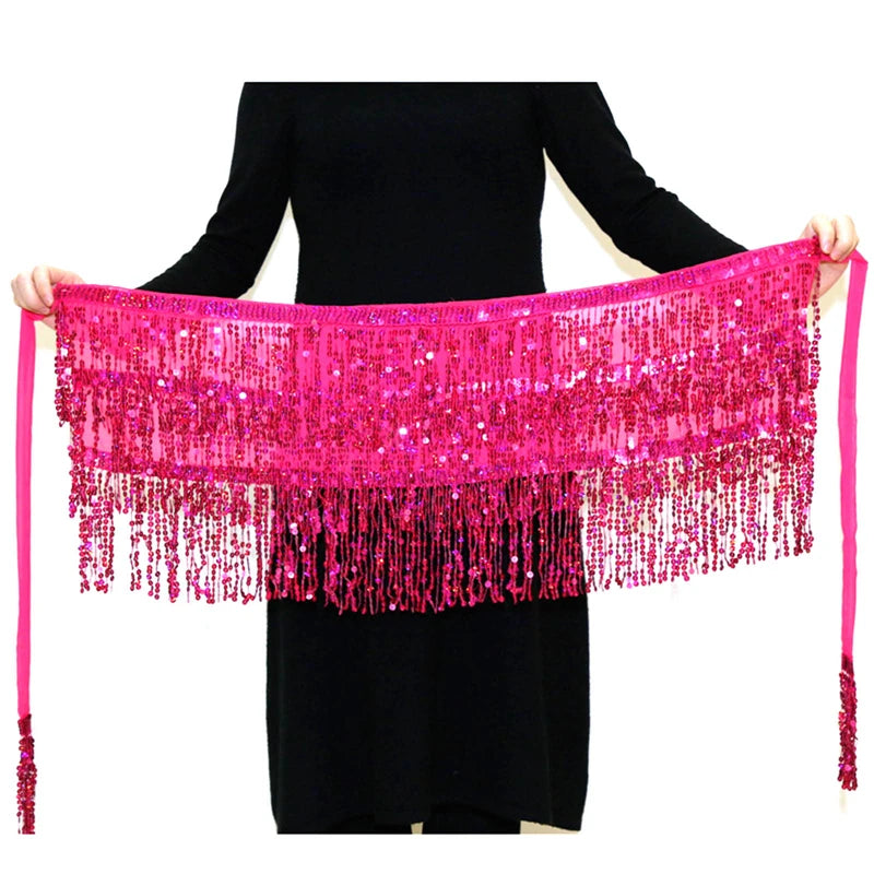 A woman models a bright pink sequin hula dancer skirt with tassel belts.