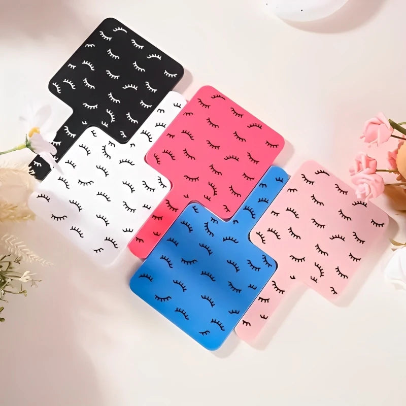 A collection of five handheld vanity mirrors in various colors including black, white, pink, and blue.