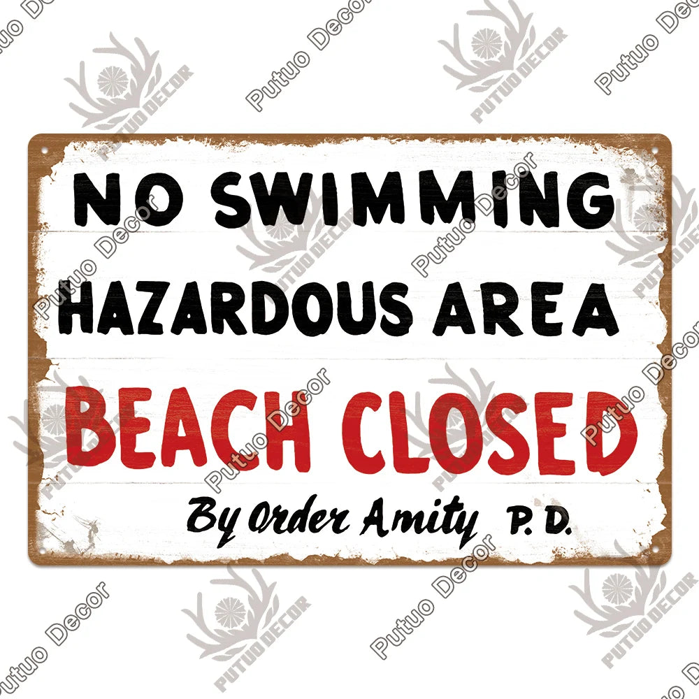 A distressed wooden sign with black text warning No Swimming Hazardous Area Beach Closed by Order Amity P.D.