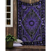 A dark purple and black bohemian mandala tapestry wall hanging displayed on a wooden surface.