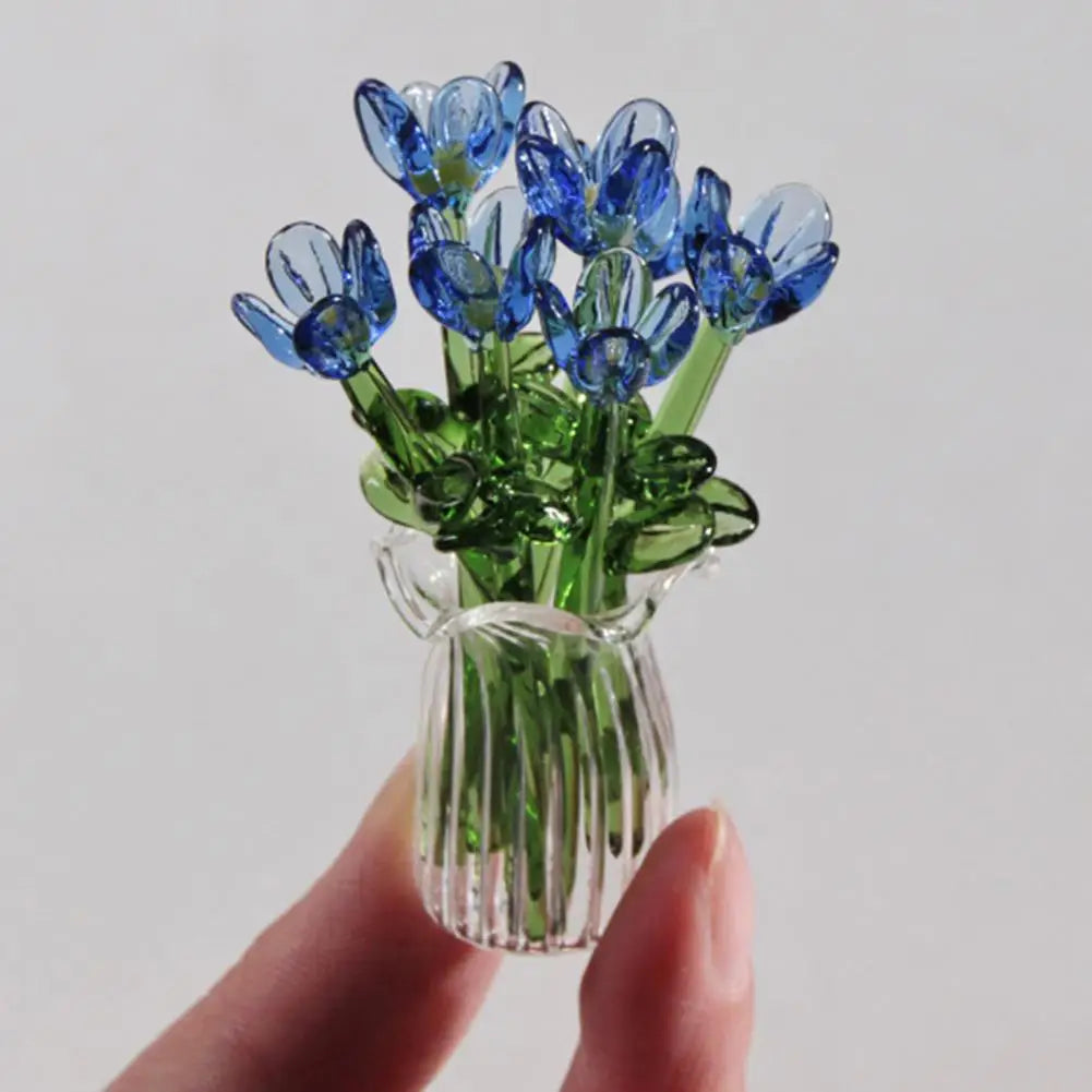 A hand-blown glass flower bouquet featuring vibrant blue tulips in a clear glass vase.