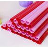A close-up view of a large pack of heart-shaped pink disposable straws in red and pink colors.