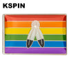 A lapel pin featuring a rainbow flag design with two butterfly shapes in the center.
