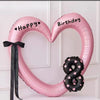 Pink heart-shaped balloon decoration with Happy and Birthday text and a black snake balloon