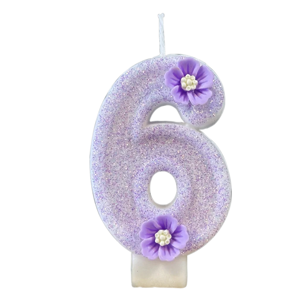 A purple sparkling number six candle decorated with small purple flowers.