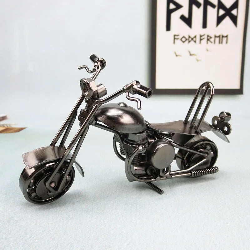 A silver-toned retro iron motorcycle figurine displayed on a light surface.